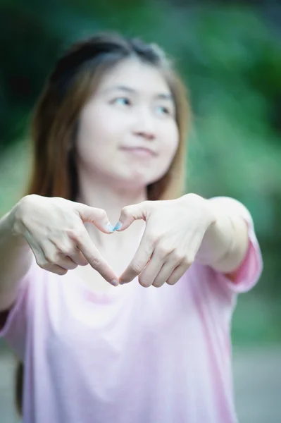 Asia feliz joven mujer haciendo señal de corazón con las manos — Foto de Stock