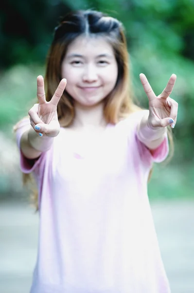 Asie krásná dívka Ukázat vítězství znamení — Stock fotografie