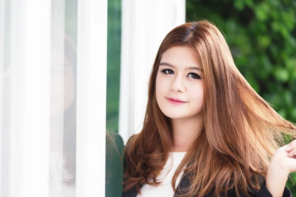 Ásia confiante jovem empresária em terno de mãos dadas no cabelo — Fotografia de Stock