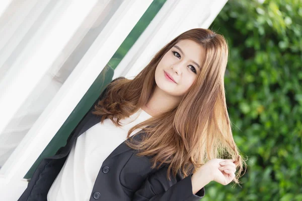 Asia confiada joven mujer de negocios en traje cogido de la mano en el pelo — Foto de Stock