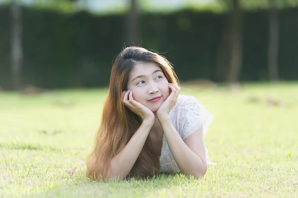 Asia hermosa joven mujer acostada en verde hierba — Foto de Stock