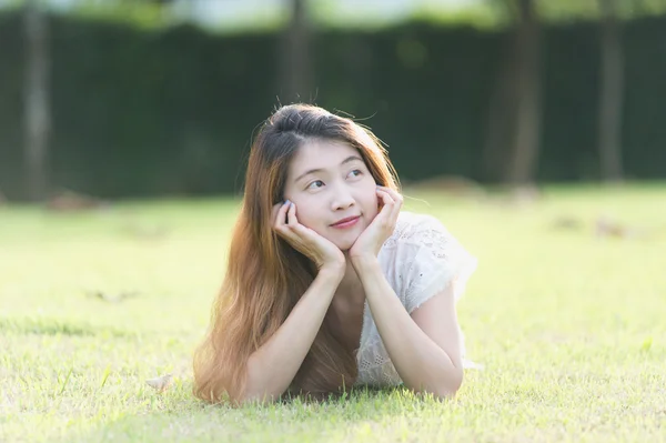 Asie belle jeune femme couchée sur l'herbe verte — Photo