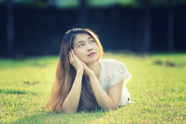 Asie belle jeune femme couchée sur l'herbe verte — Photo