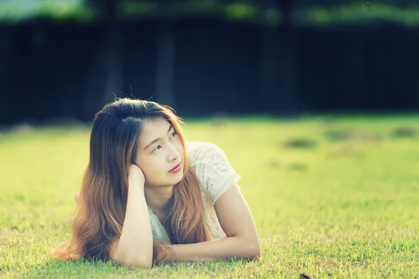 Asia bella giovane donna sdraiata su erba verde — Foto Stock