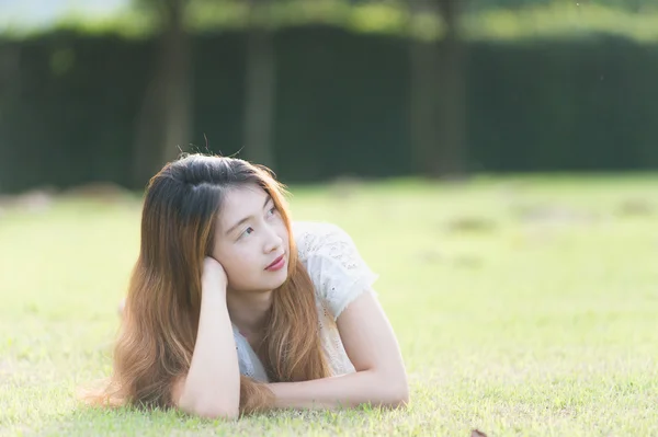 Asia bella giovane donna sdraiata su erba verde — Foto Stock