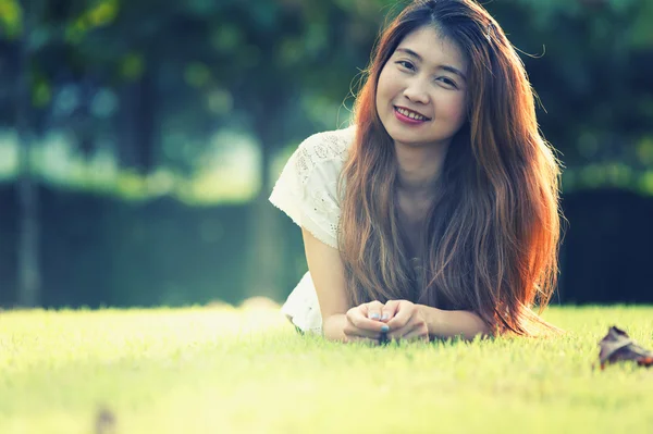 Asia hermosa joven mujer acostada en verde hierba — Foto de Stock