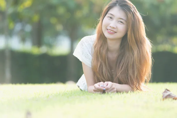 Asia bella giovane donna sdraiata su erba verde — Foto Stock