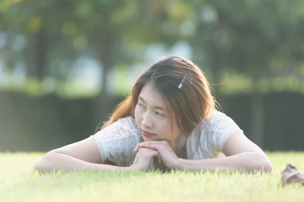 Asie belle jeune femme couchée sur l'herbe verte — Photo