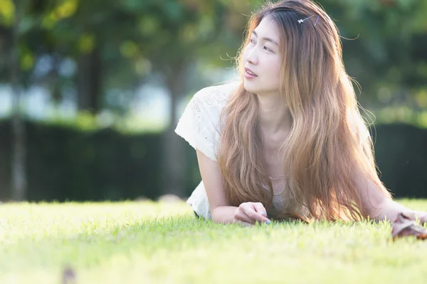 Asia bella giovane donna sdraiata su erba verde — Foto Stock