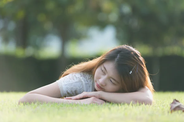 Asie belle jeune femme couchée sur l'herbe verte — Photo