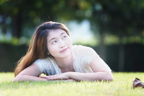 Asie belle jeune femme couchée sur l'herbe verte — Photo