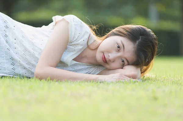 Asie belle jeune femme couchée sur l'herbe verte — Photo