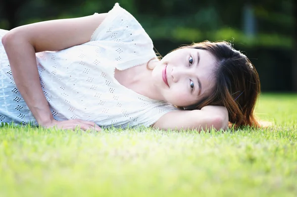 Ázsiában a gyönyörű fiatal nő feküdt a zöld fű — Stock Fotó