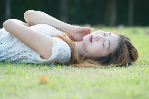 Asie belle jeune femme couchée sur l'herbe verte — Photo