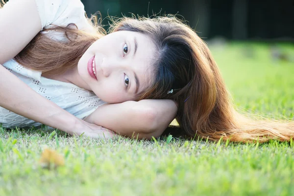 Asie belle jeune femme couchée sur l'herbe verte — Photo