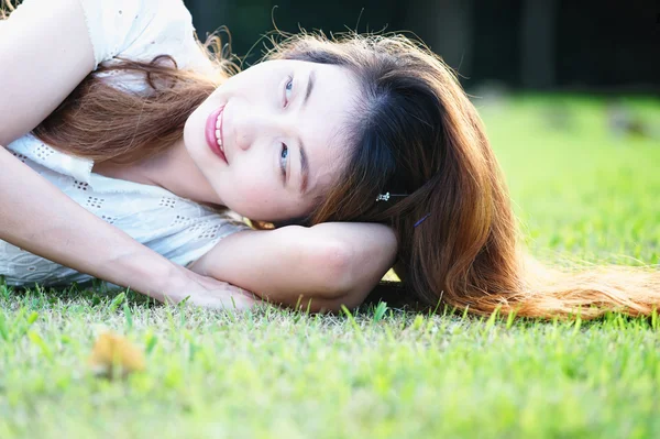 Asia piękna młoda kobieta leżący na zielonej trawie — Zdjęcie stockowe