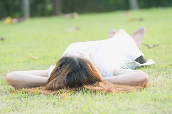 Asie krásná mladá žena leží na zelené trávě — Stock fotografie