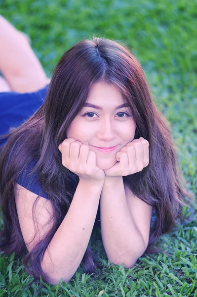 Азія красива усміхнена жінка лежить на траві — стокове фото