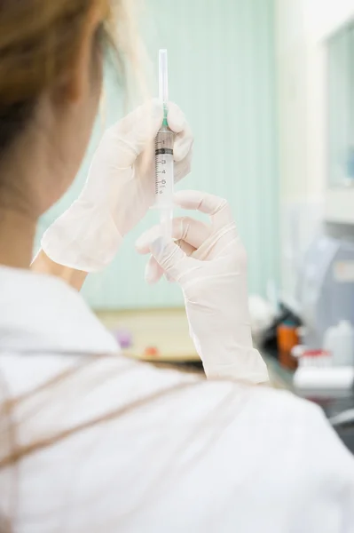 Junge Ärztin mit Spritze im Krankenhaus — Stockfoto