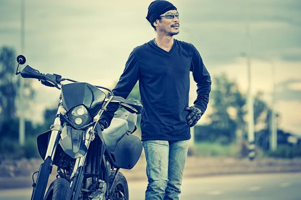 Retrato del hombre ciclista de pie en la carretera con la motocicleta — Foto de Stock