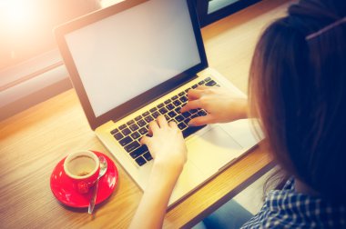 Kahve molası sırasında dizüstü bilgisayar kullanan kadın