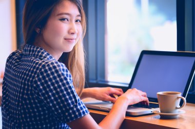 Asya onu laptop kullanarak ve kafede kahve içme güzel