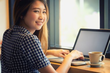 Asya onu laptop kullanarak ve kafede kahve içme güzel