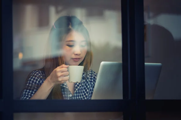 Mujer asia beber café y trabajar en el ordenador portátil en la cafetería — Foto de Stock