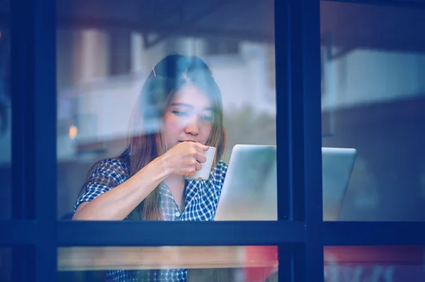 Mujer asia beber café y trabajar en el ordenador portátil en la cafetería — Foto de Stock