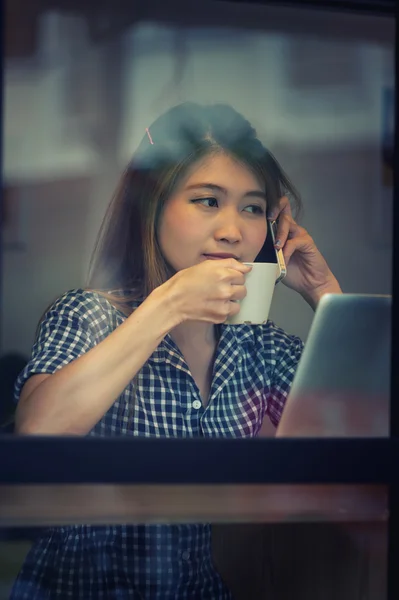 Mujer asia beber café y trabajar en el ordenador portátil en la cafetería — Foto de Stock