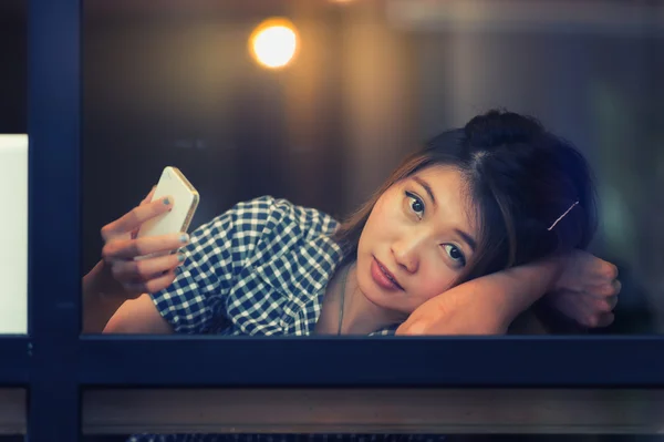 Женщина, сидящая за барным столом и снимающая происходящее на мобильный телефон — стоковое фото