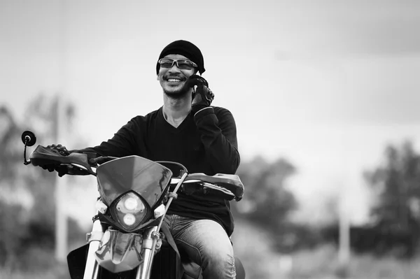 Азия красивый мужчина байкер звонит по телефону на мотоцикле — стоковое фото