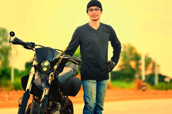 Porträtt av man biker stående på vägen med motorcykel — Stockfoto