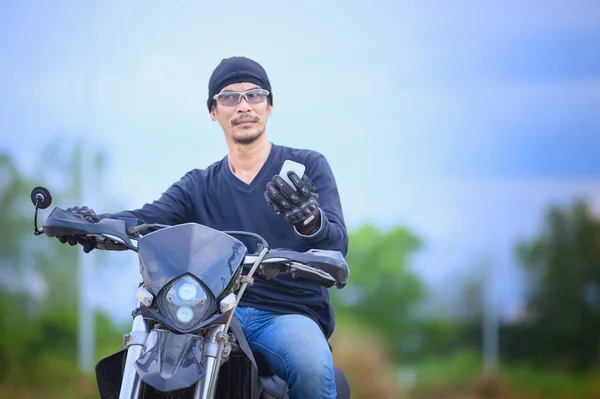 Asiatisch gut aussehender mann biker telefon auf dem motorrad — Stockfoto