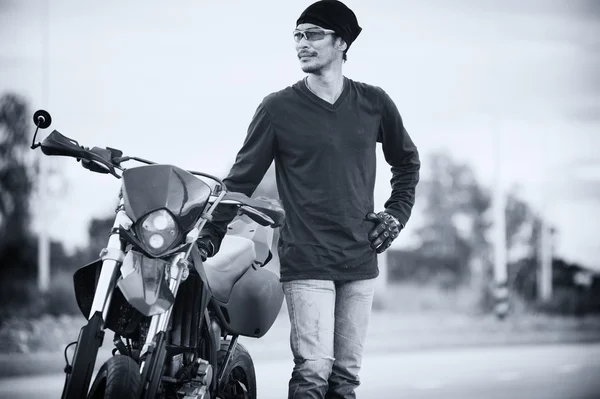 Retrato del hombre ciclista de pie en la carretera con la motocicleta —  Fotos de Stock