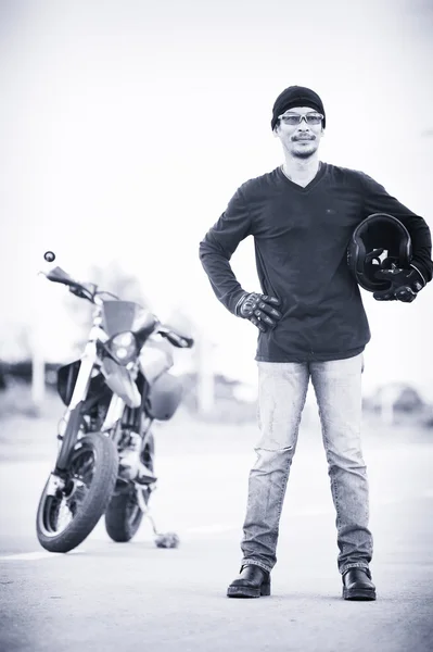 Retrato de homem motociclista de pé na estrada com motocicleta — Fotografia de Stock