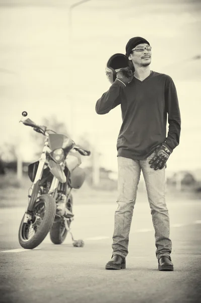 Retrato de homem motociclista de pé na estrada com motocicleta — Fotografia de Stock