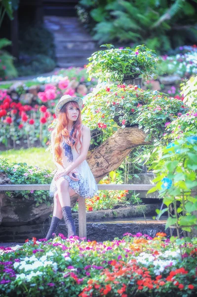 Asia mujeres jóvenes sentadas en colorido jardín de flores — Foto de Stock