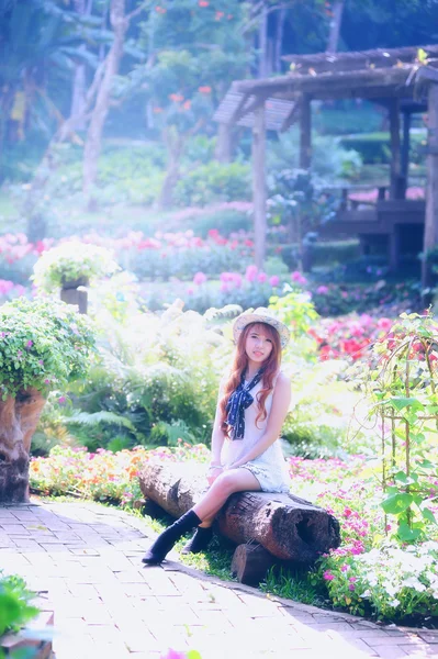 Asia young women sitting in colorful flower garden — Stock Photo, Image