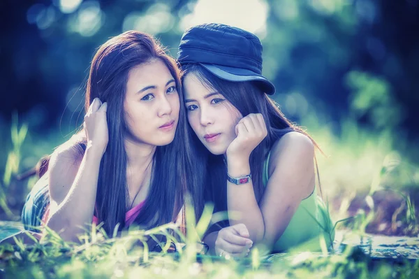 Zwei junge asiatische Frauen liegen auf Gras — Stockfoto