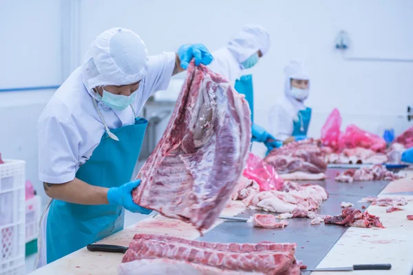 Skära kött slakteriarbetare i fabriken — Stockfoto