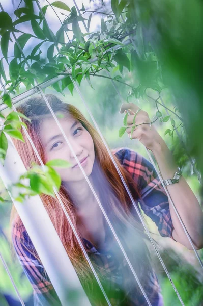 Asia młoda kobieta w parku i patrząc na kamery — Zdjęcie stockowe