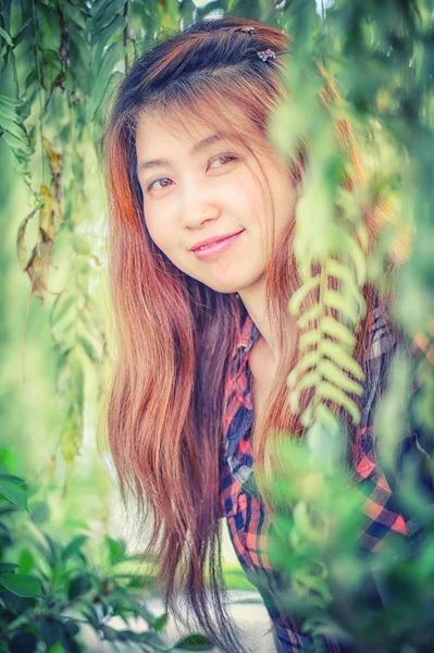Asie mladá žena v parku a při pohledu na fotoaparát — Stock fotografie