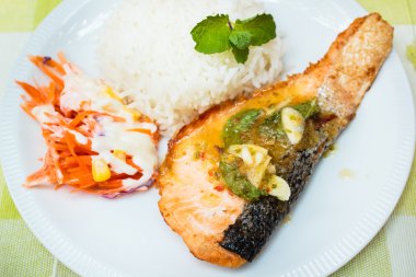 Pirinç ve somon steak baharatlı sos ile.