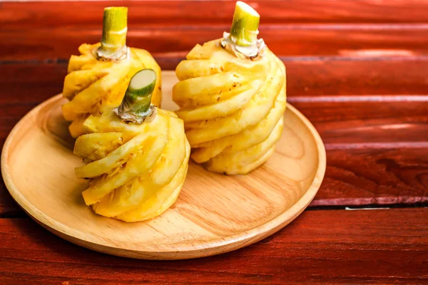 Pineapple on wood plate. — Stock Photo, Image