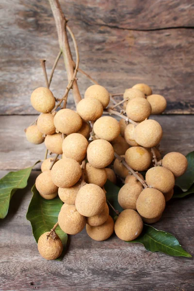 Longan na velha mesa de madeira . — Fotografia de Stock