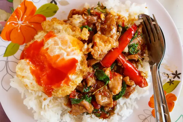 Rice topped with stir fried hot and spicy pork with basil and fr — Stock Photo, Image