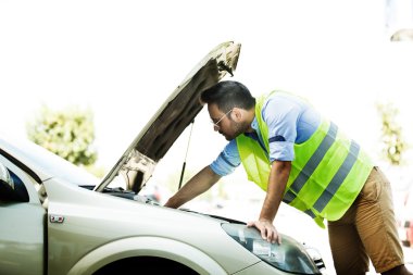 Genç adam araba sorun yaşıyor. 