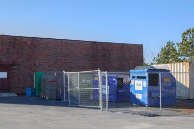Columbia County, Ga USA - 01 30 21: Blue ORION Trash waste dumpsters on the side of a building with fence