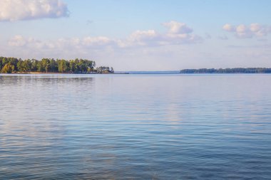 Mavi gökyüzü ve bulutlarla güzel bir göl sahnesi